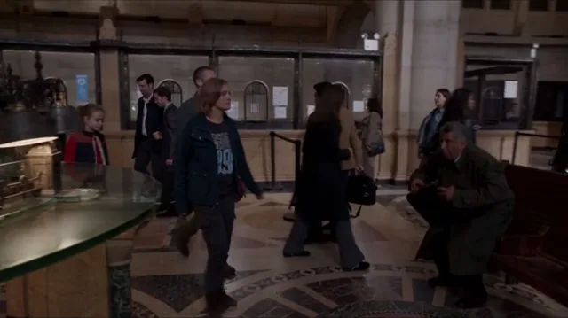 A still from Believe: people walking through a crowded hall