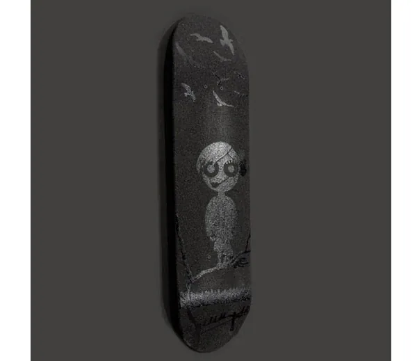 A black skateboard deck with a gray girl with round eyes