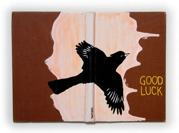 A black bird in silhouette over white and brown, with the words Good Luck
