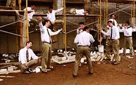 Young men in white shirts and ties posed across a scaffold