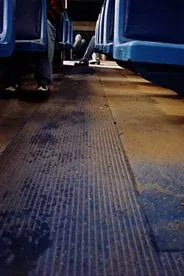 The empty aisle of a bus, seen from the floor