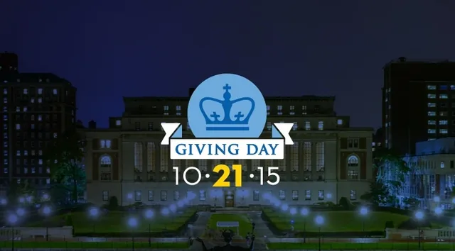 The Giving Day logo, a crown over the date 10·21·15, glowing above the campus at night