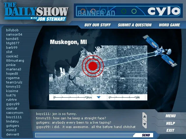 The PC screen: The Daily Show logo, a banner ad slot with the Cylo logo, and Buy Our Stuff, Submit a Question and Word Game across the top; a list of chat names down the left; in the middle a satellite targets Muskegon, MI on an aerial photo; below, the chat (jon is so funny) with Menu, Help and Exit