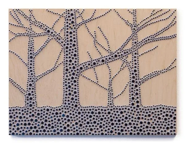 Bare trees outlined in googly eyes on a light wood panel