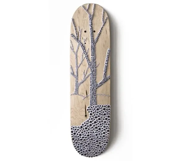 A skateboard deck with a tree and a ground of googly eyes