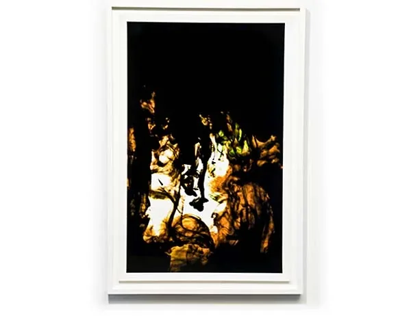 Light breaking through black, in a tall white frame