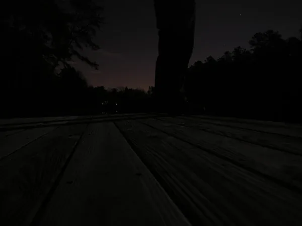 A dock at night, a silhouette against the dark sky