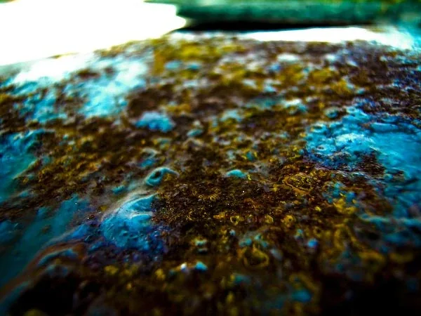 A crusted surface of blue and brown, in close-up