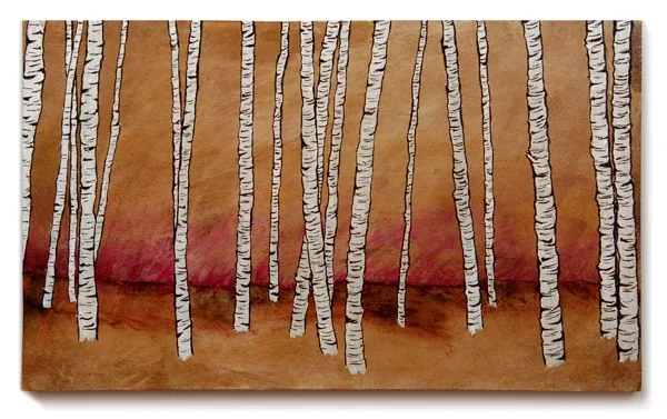 White birch trunks standing on red ground, on stained wood