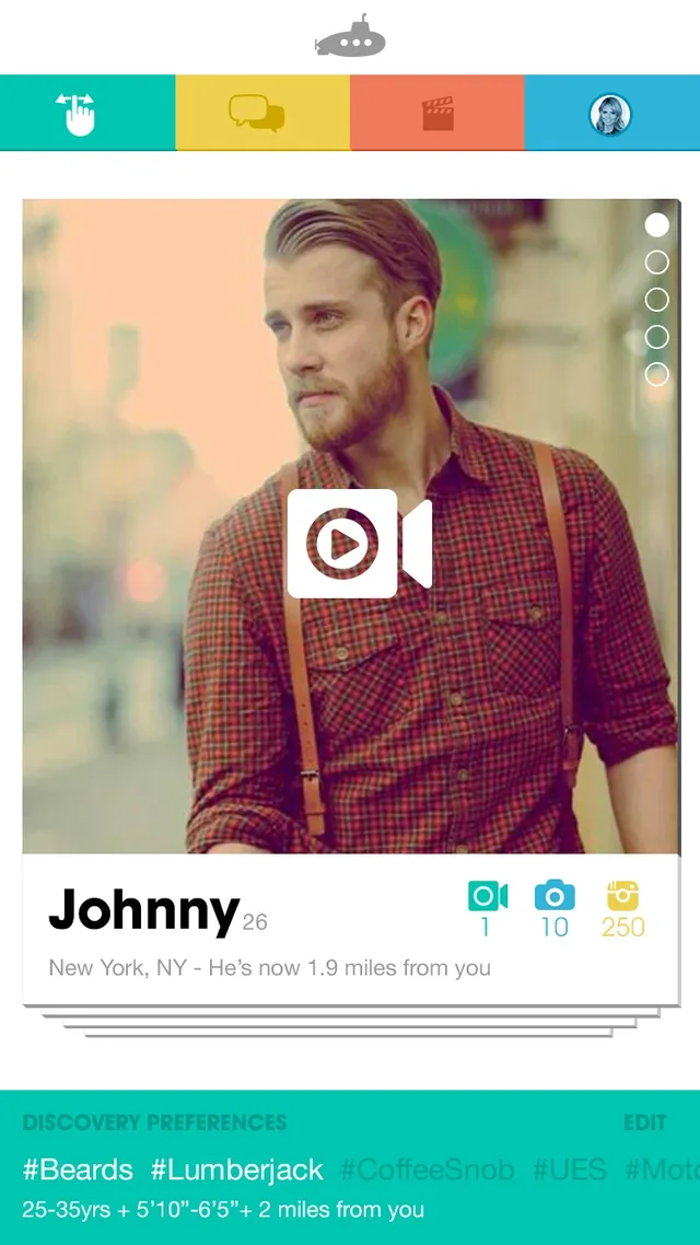The Submarine home screen: a gray submarine logo over four colored tabs, then a deck of profile cards topped by Johnny, 26, New York, he’s now 1.9 miles from you, with a play button over his photo and counts of 1 video, 10 photos and 250 Instagram posts. A teal bar below holds your discovery preferences: #Beards, #Lumberjack, 25 to 35, 5′10″ to 6′5″, within 2 miles