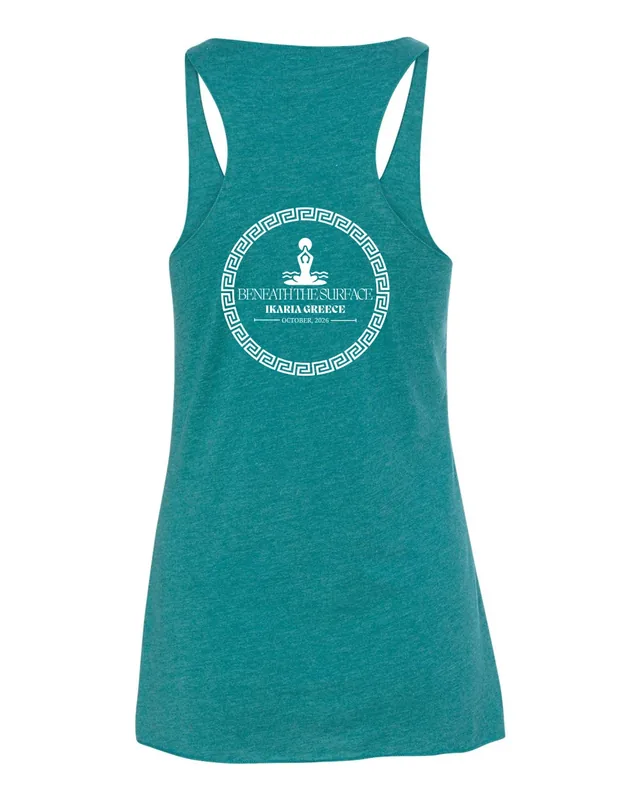 The back of a teal racerback tank printed with the retreat’s round white badge: a seated figure inside a Greek key, Beneath the Surface, Ikaria Greece, October 2026