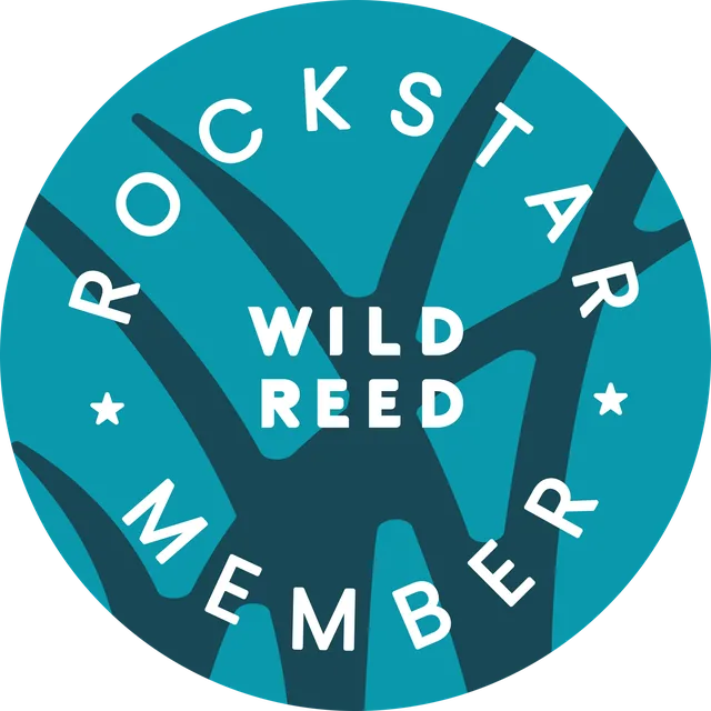 A round teal magnet: ROCKSTAR MEMBER around the edge and WILD REED in the middle, over dark teal reeds